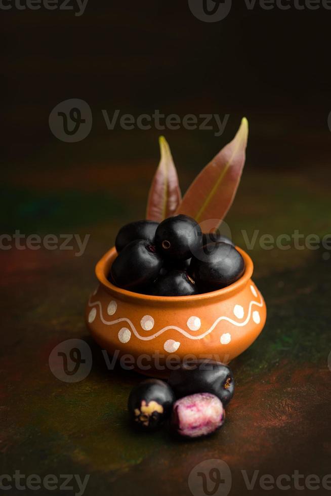 ameixa jambolan ou fruta jambul ou jamun, java plum syzygium cumini em plano de fundo texturizado. foto