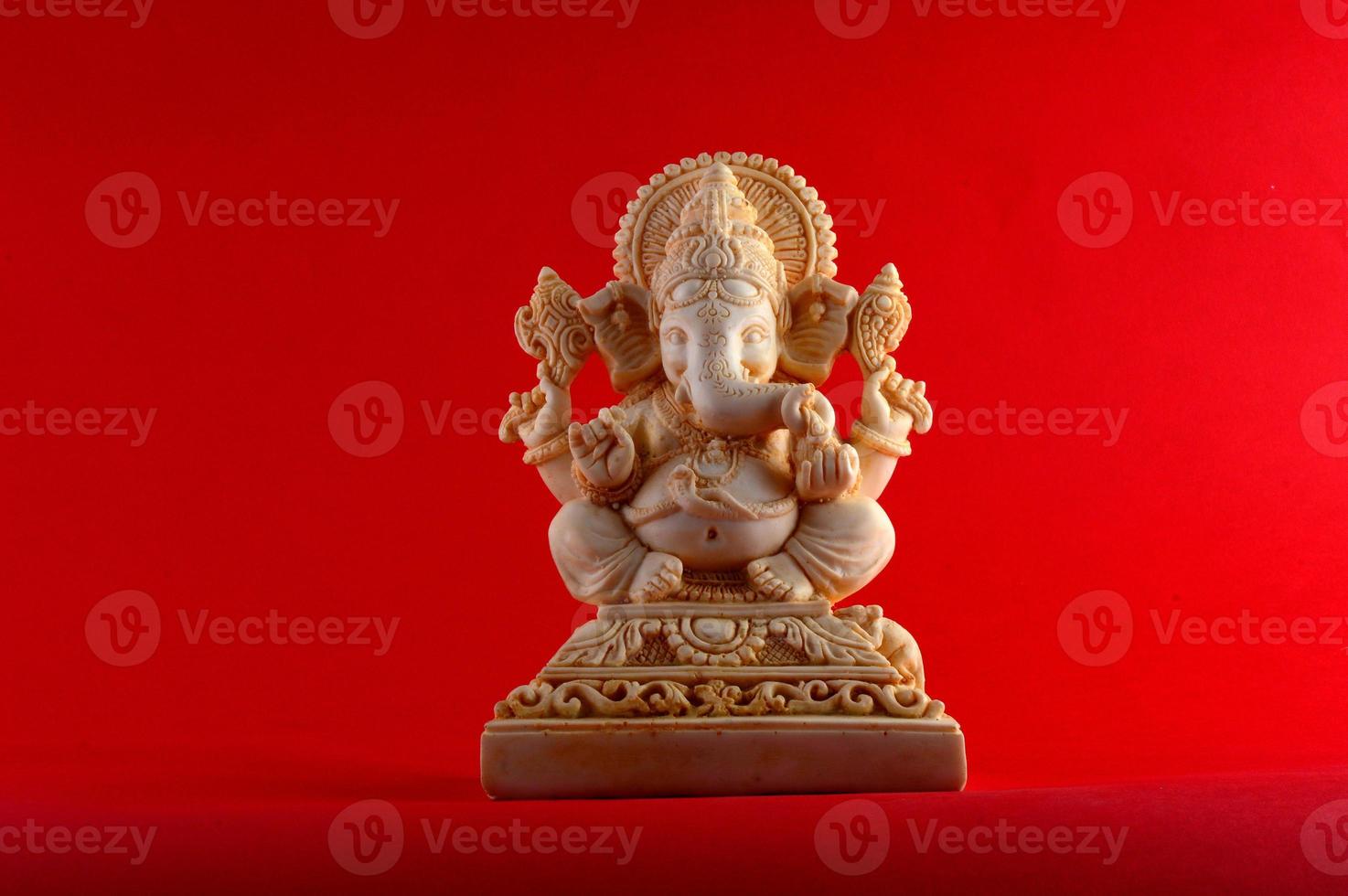 deus hindu ganesha. ídolo ganesha em fundo vermelho foto