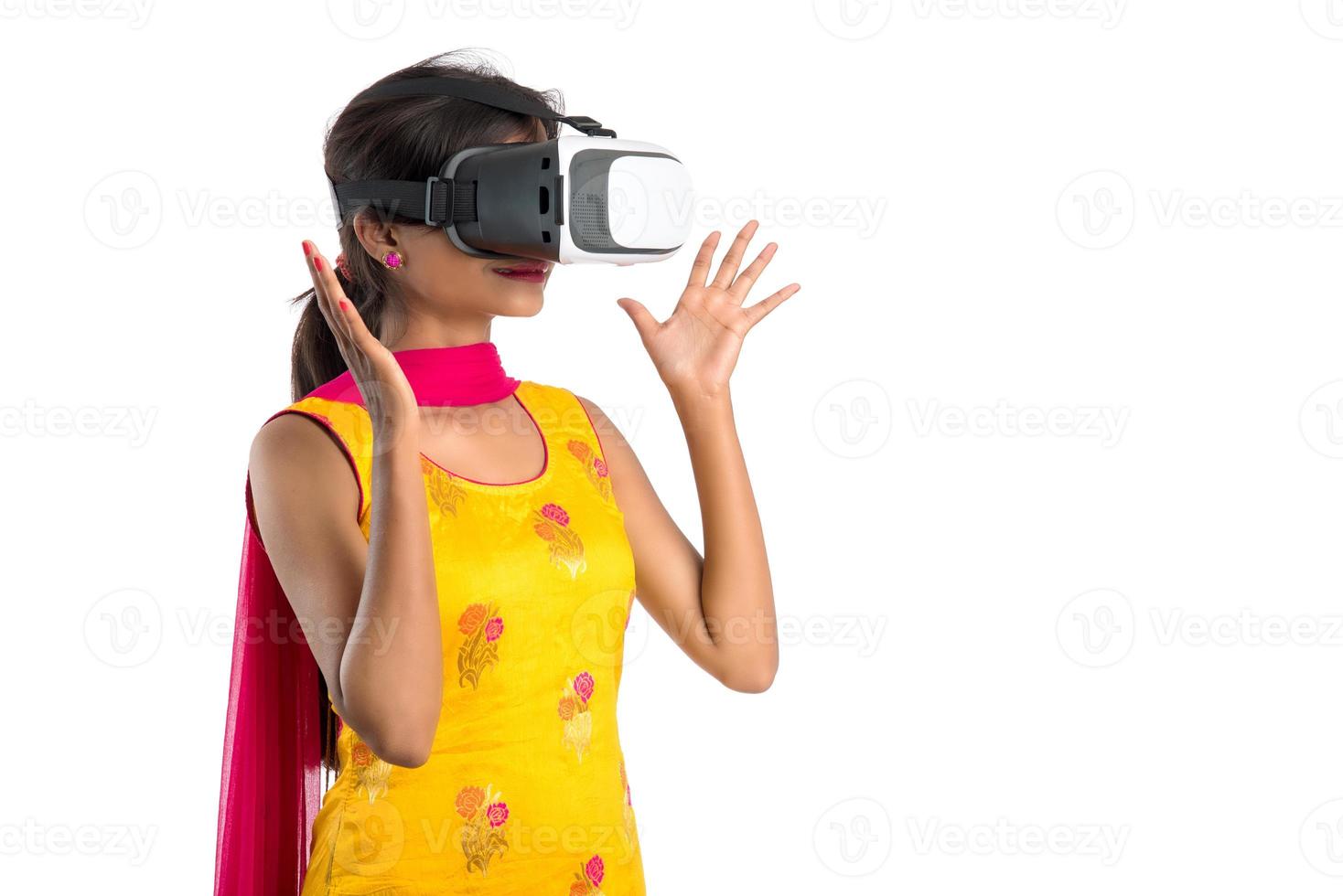 jovem tradicional indiana segurando e mostrando o dispositivo de vr, caixa de vr, óculos de proteção, fone de ouvido de óculos de realidade virtual 3d, garota com tecnologia futura de imagem moderna em fundo branco. foto