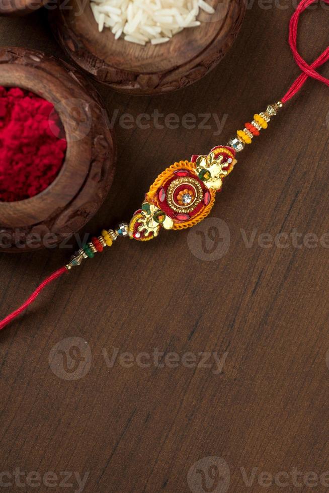 fundo indiano festival raksha bandhan com um elegante rakhi, grãos de arroz e kumkum. uma pulseira tradicional indiana que é um símbolo de amor entre irmãos e irmãs. foto