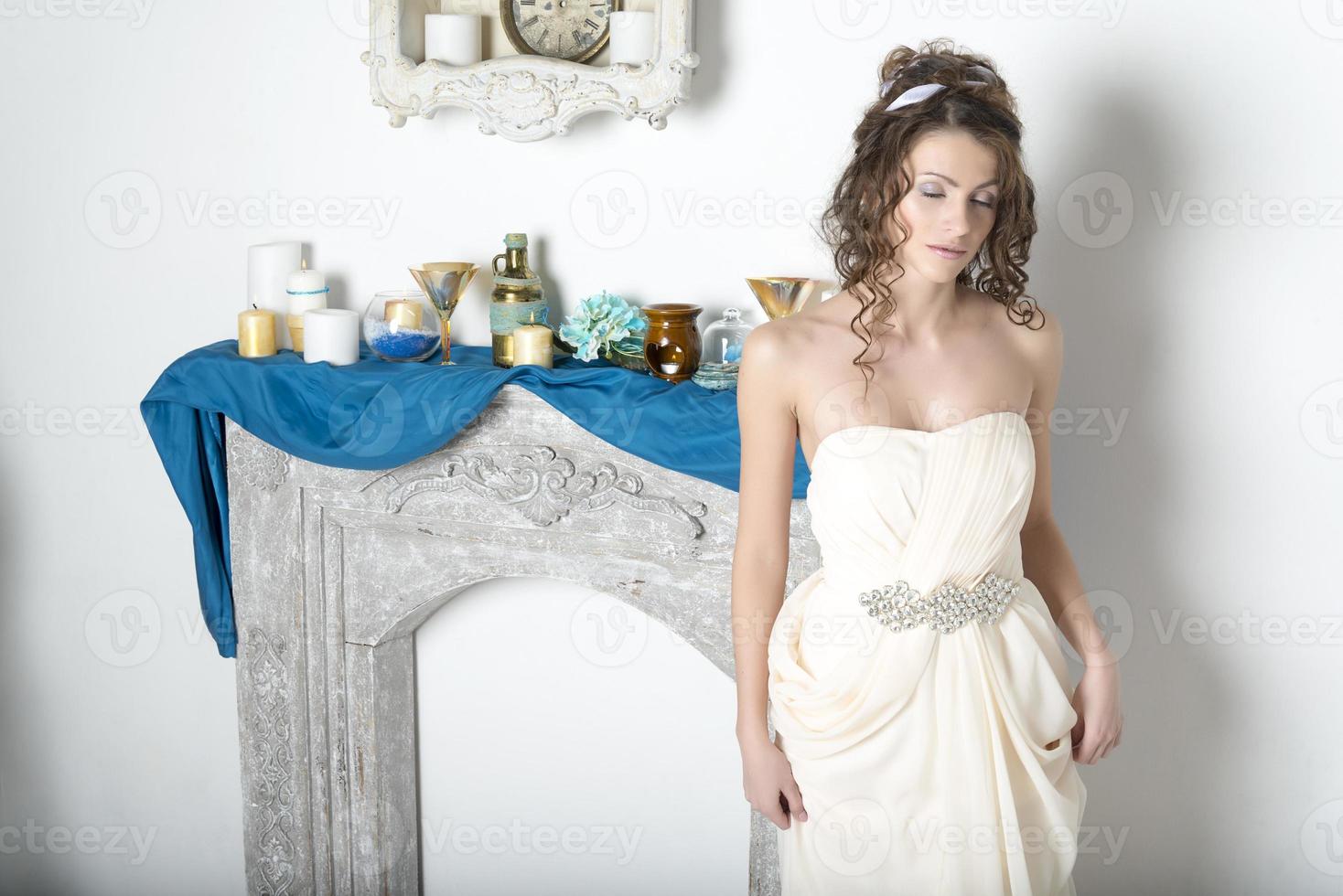garota de branco perto da lareira decorativa. foto