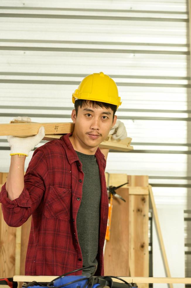 carpinteiro jovem asiático trabalha para clientes meticulosamente, ele é um jovem, um empresário de sucesso e muito habilidoso. foto