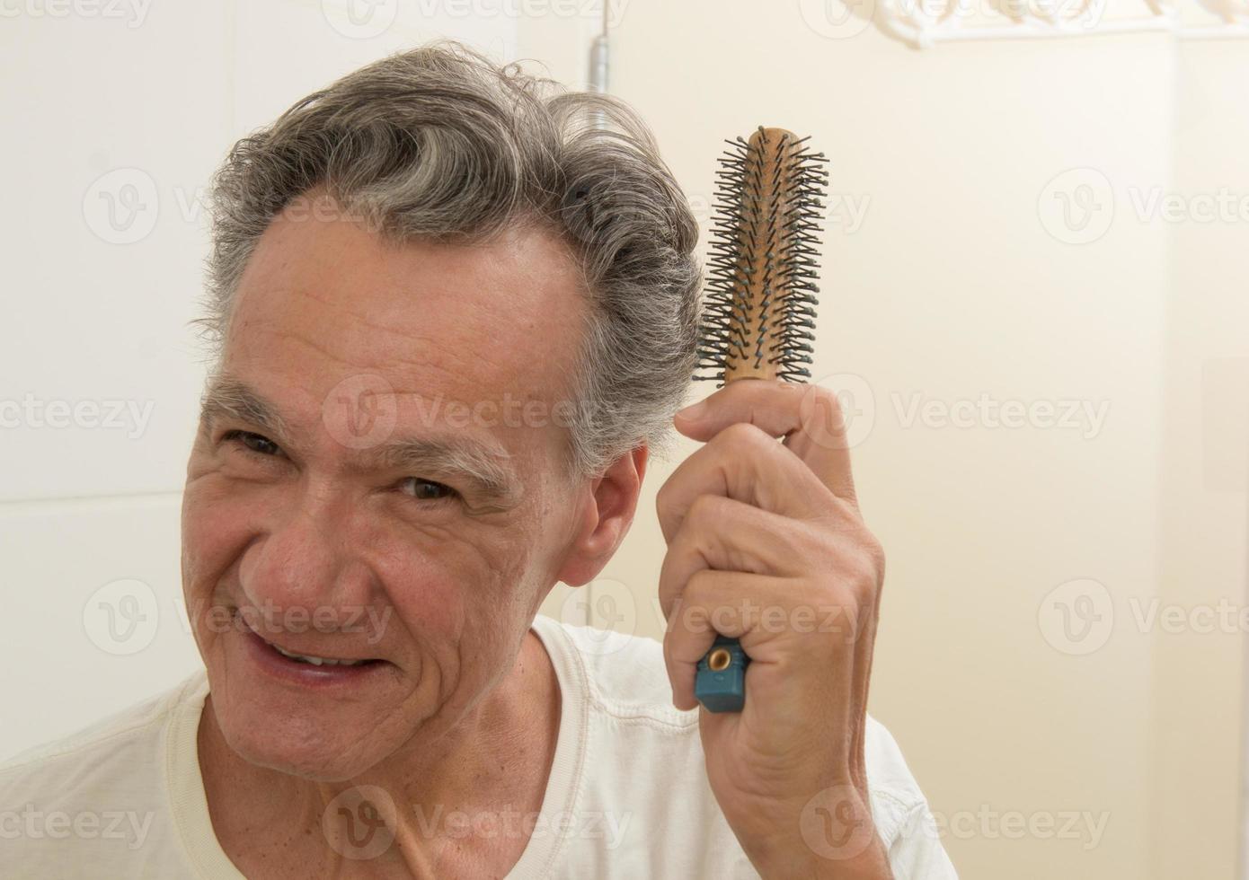 homem maduro escovando e penteando o cabelo foto