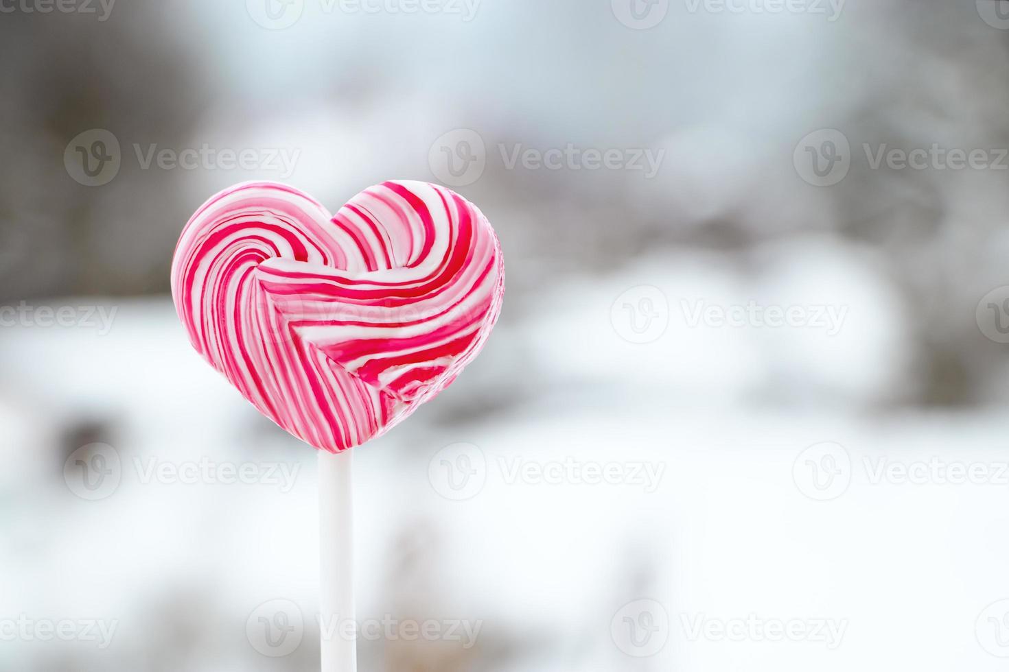 pirulito rosa em forma de coração. doce de caramelo no palito. doce presente para o dia dos namorados. foto