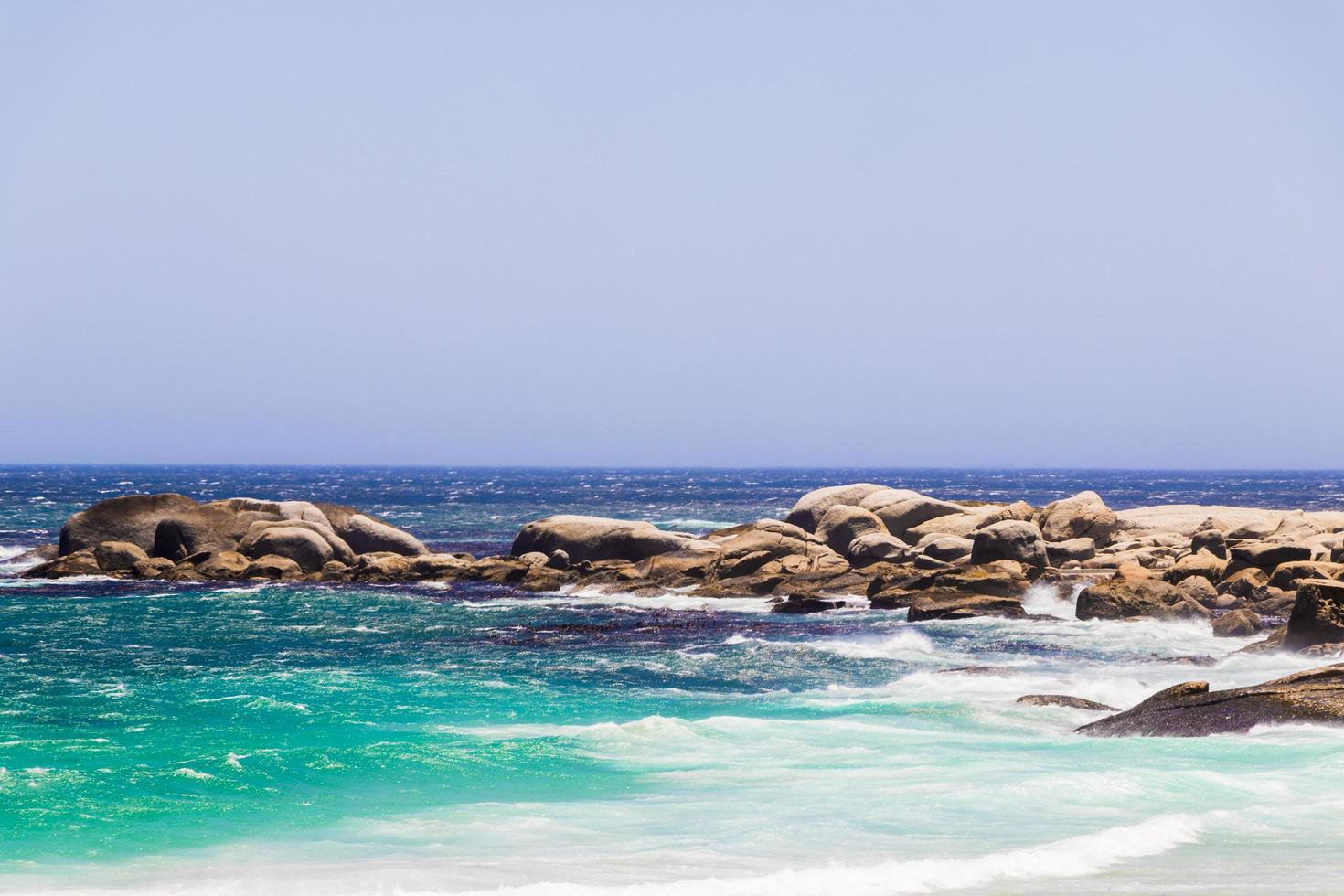 rochas da água turquesa da praia da baía dos acampamentos, cidade do cabo, áfrica do sul. foto