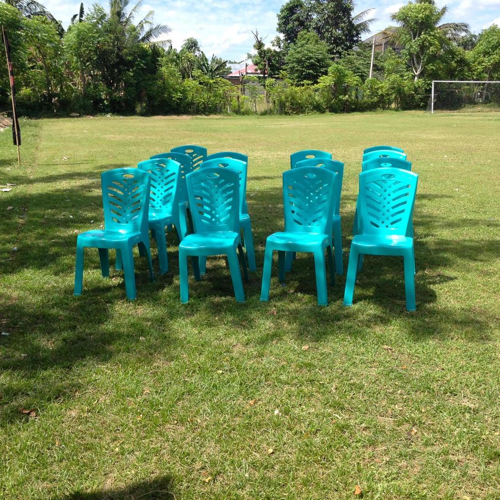 cadeiras de plástico azuis dispostas no campo foto