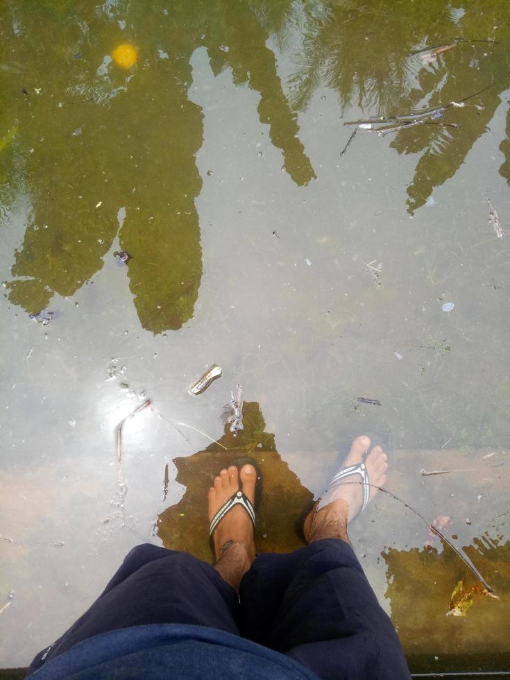 foto dos pés de um homem imersos em água.