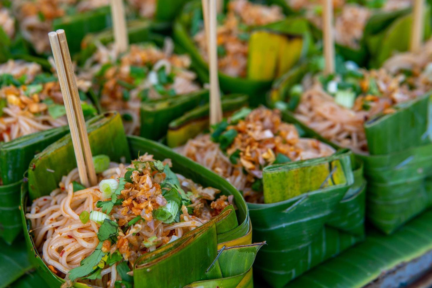 pequena porção de pad thai em folha na rua foto