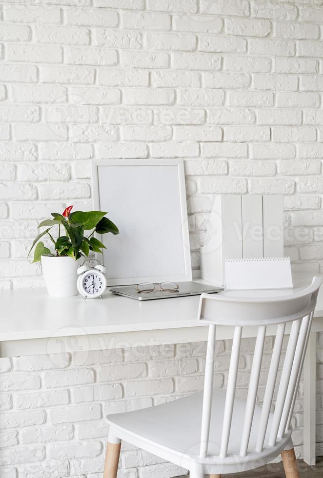 vista frontal da disposição da mesa com calendário em branco para simulação, pastas de papel e moldura branca com espaço de cópia foto