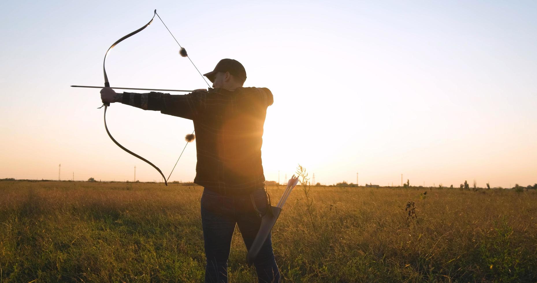 homem com arco ao ar livre no campo foto