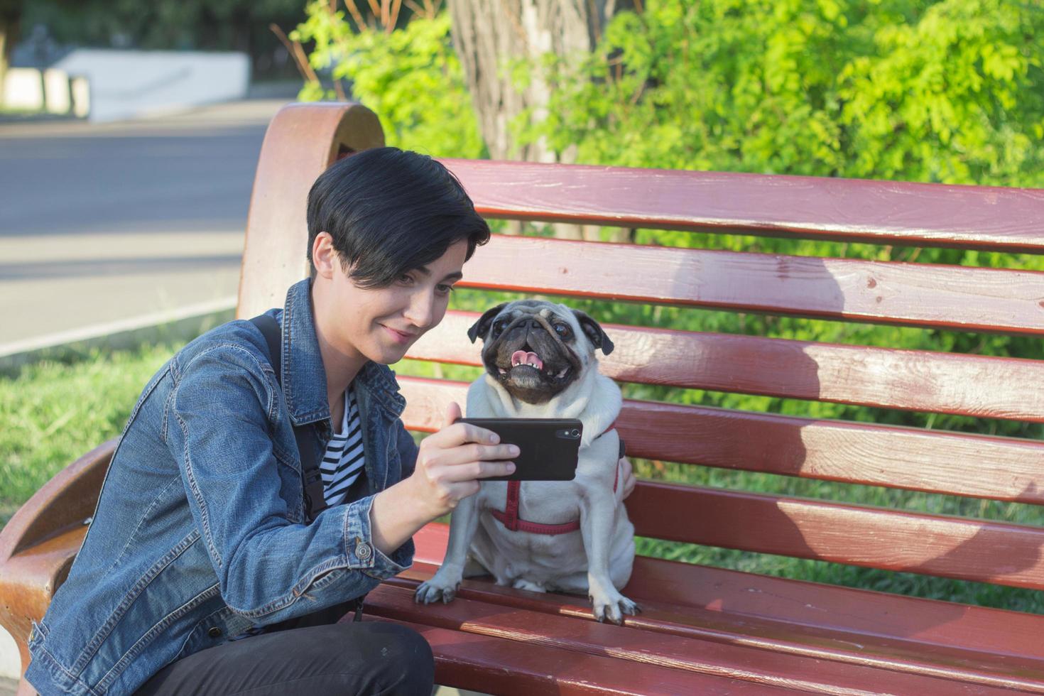 retrato de mulher jovem com cachorro pug no parque foto