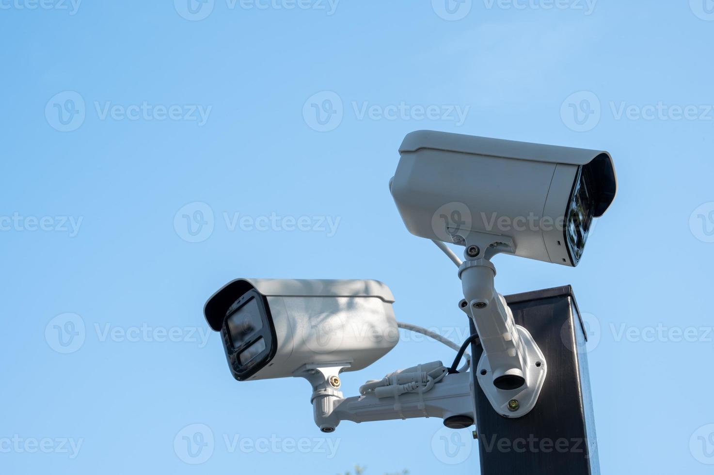 duas máquinas de monitoramento na beira da estrada sob o céu azul foto