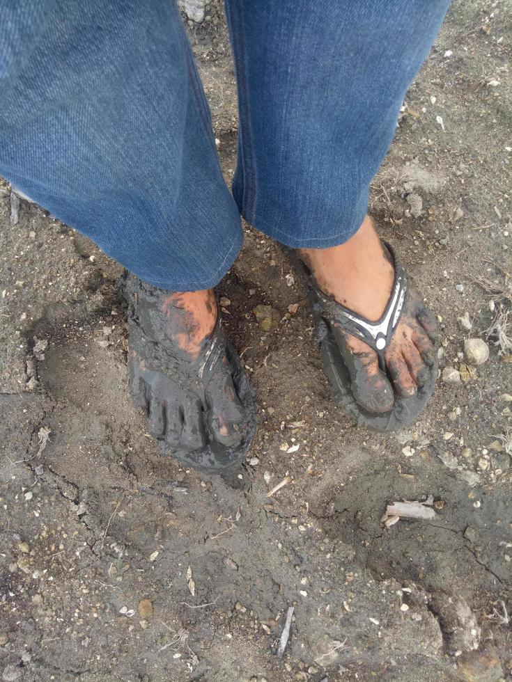 a aparência dos pés de um homem cobertos de lama. pés de homem com lama bioconstrução permacultura foto