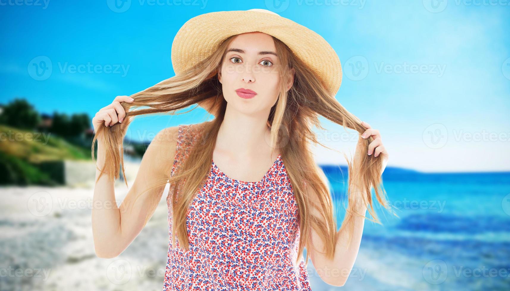 garota com cabelo bonito com um chapéu de verão na praia foto