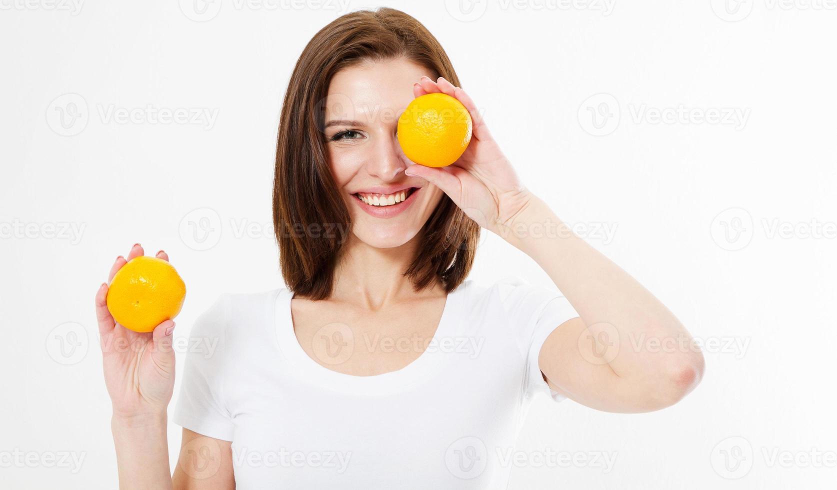 sorriso positivo morena feliz segurando uma laranja perto do rosto, conceito de dieta cosmética foto