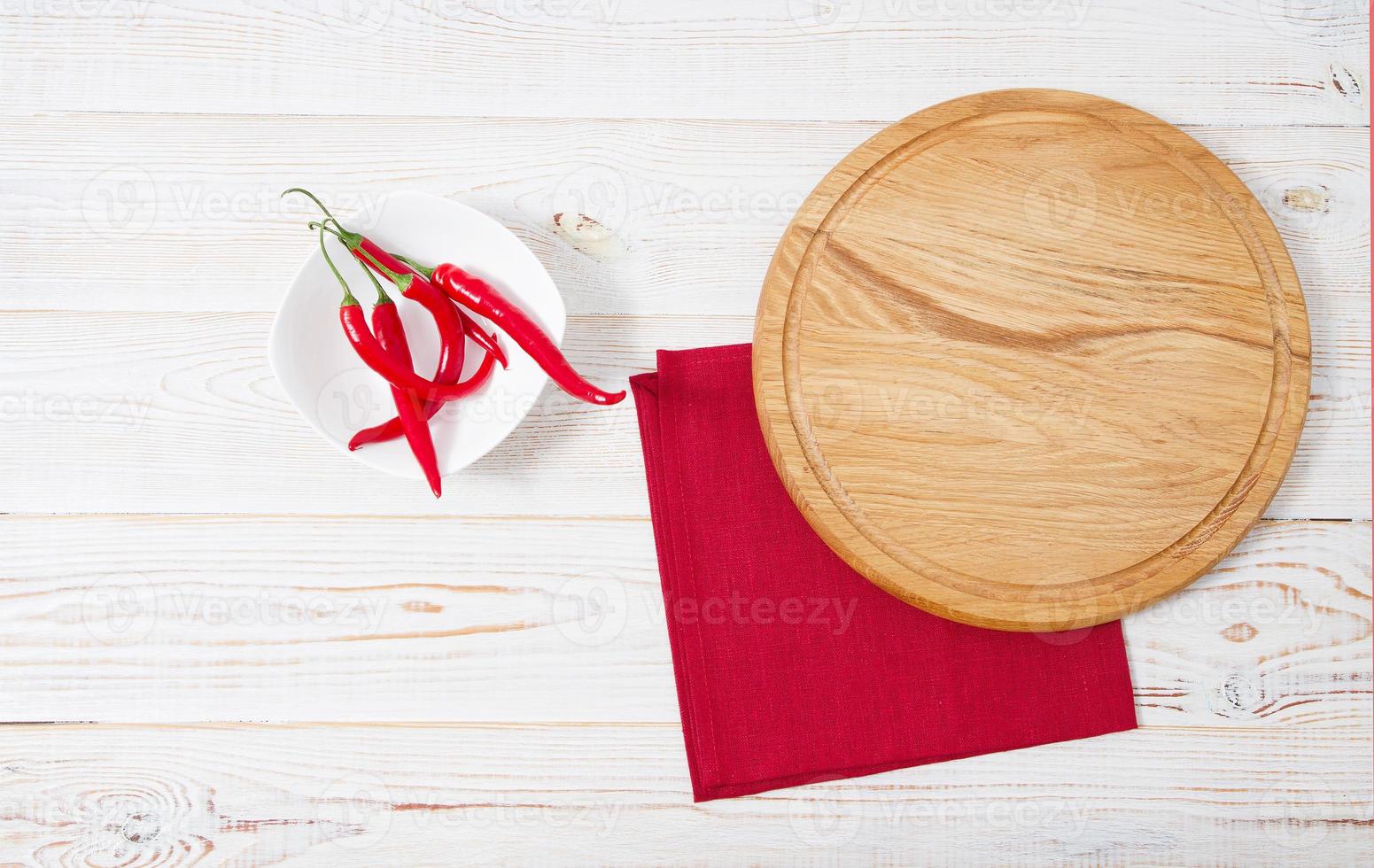 mesa de madeira, guardanapo vermelho, pimenta vermelha na mesa. conceito de férias de mesa de mesa foto