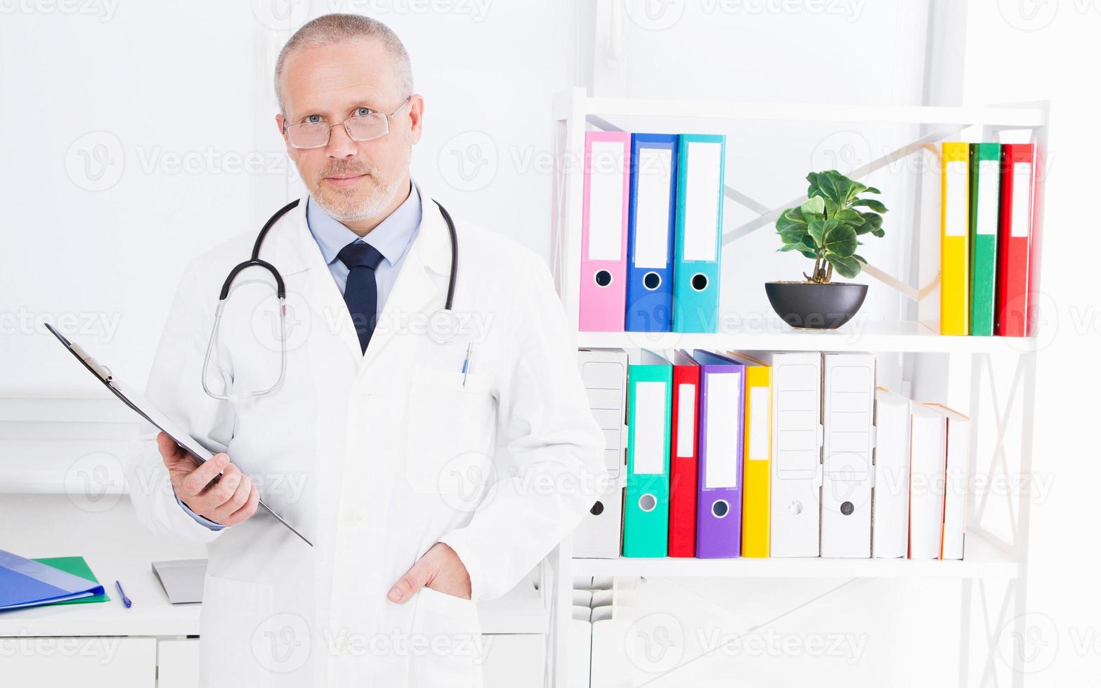 médico com pasta posando no consultório médico da clínica foto