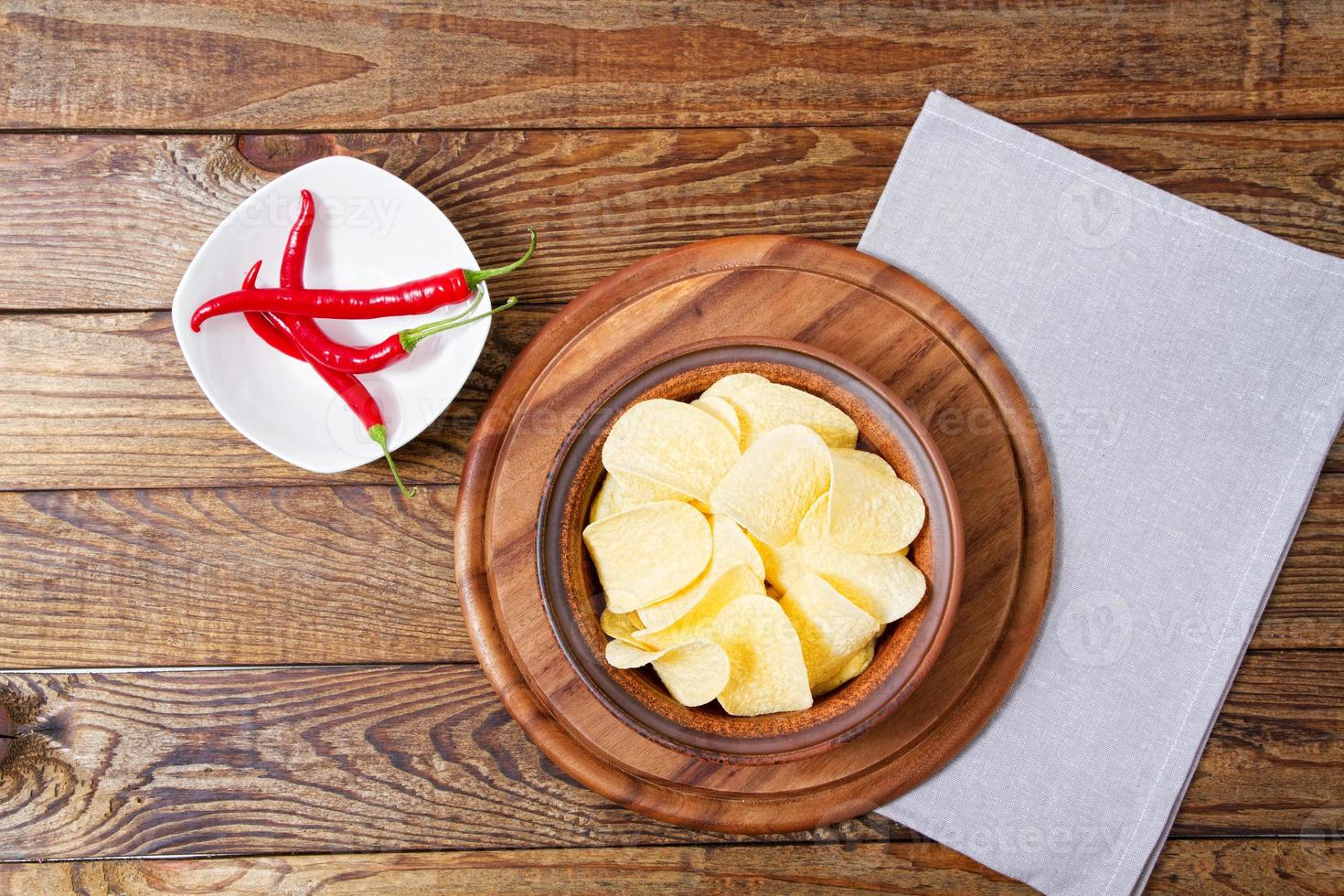 batata frita, pimenta malagueta, guardanapo no fundo da mesa de madeira, simulação de foto