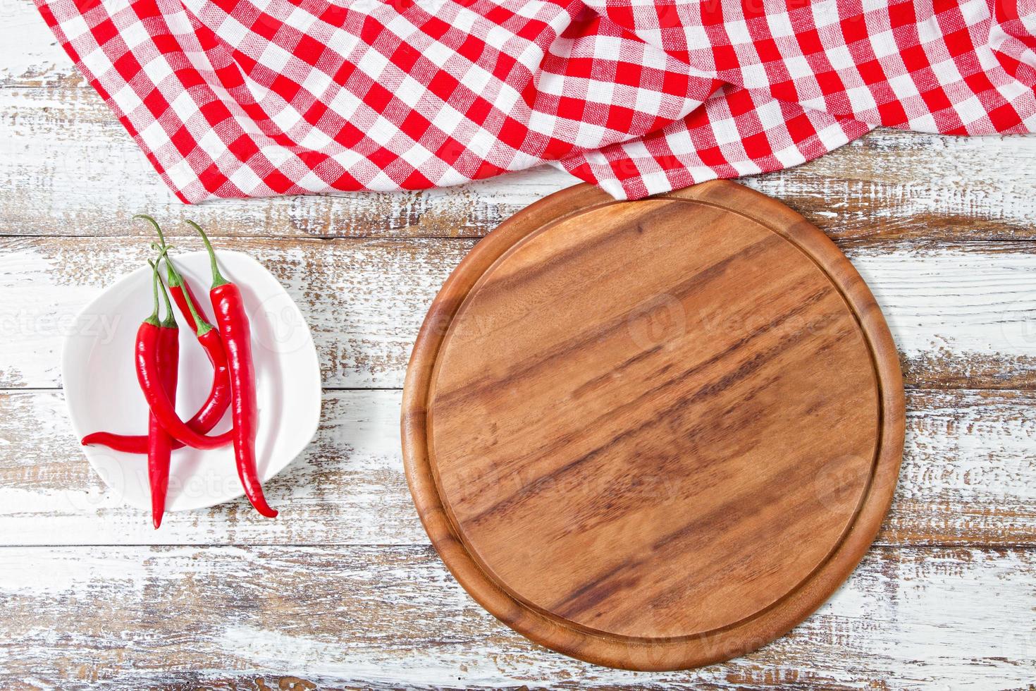 vista de cima toalha de mesa vermelha enrugada, pimenta e prancha na mesa de madeira, mock up foto