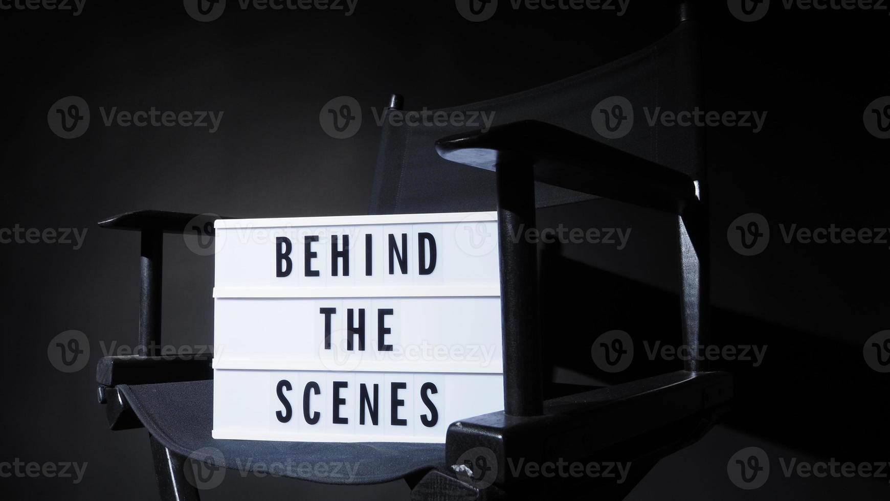 cadeira do diretor com caixa de luz de banner atrás da cena. foto