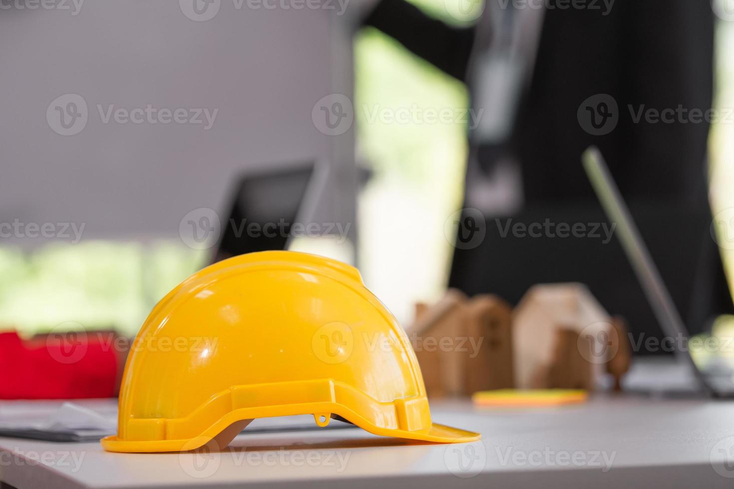 capacete amarelo na mesa de trabalho equipe de trabalho reunião fundo foto