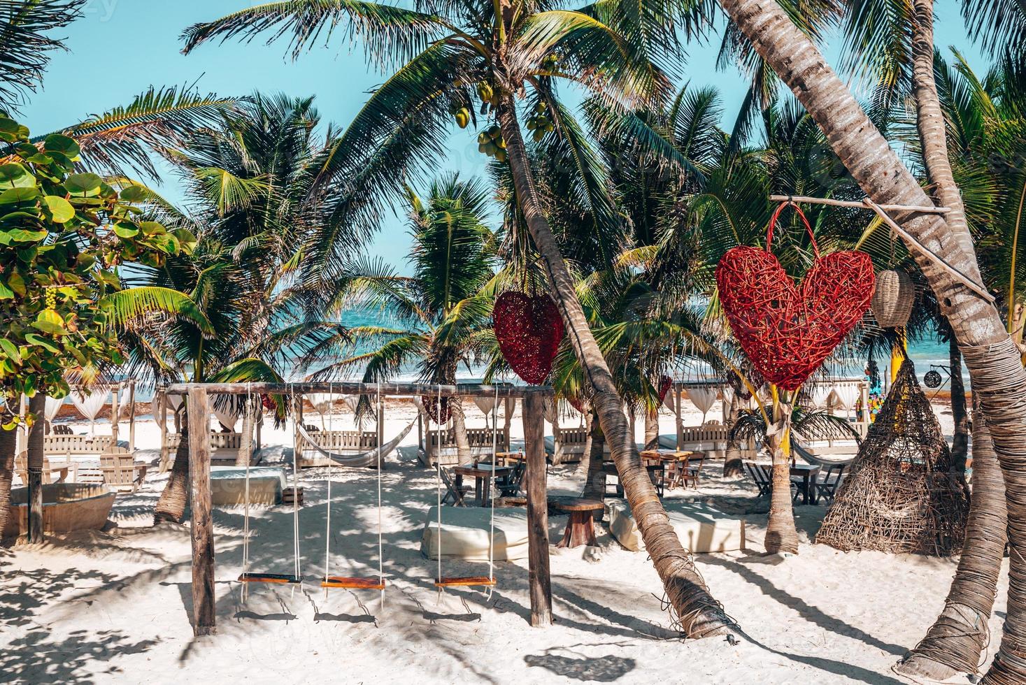 balanço vazio com objeto em forma de coração pendurado em uma árvore no resort de praia foto