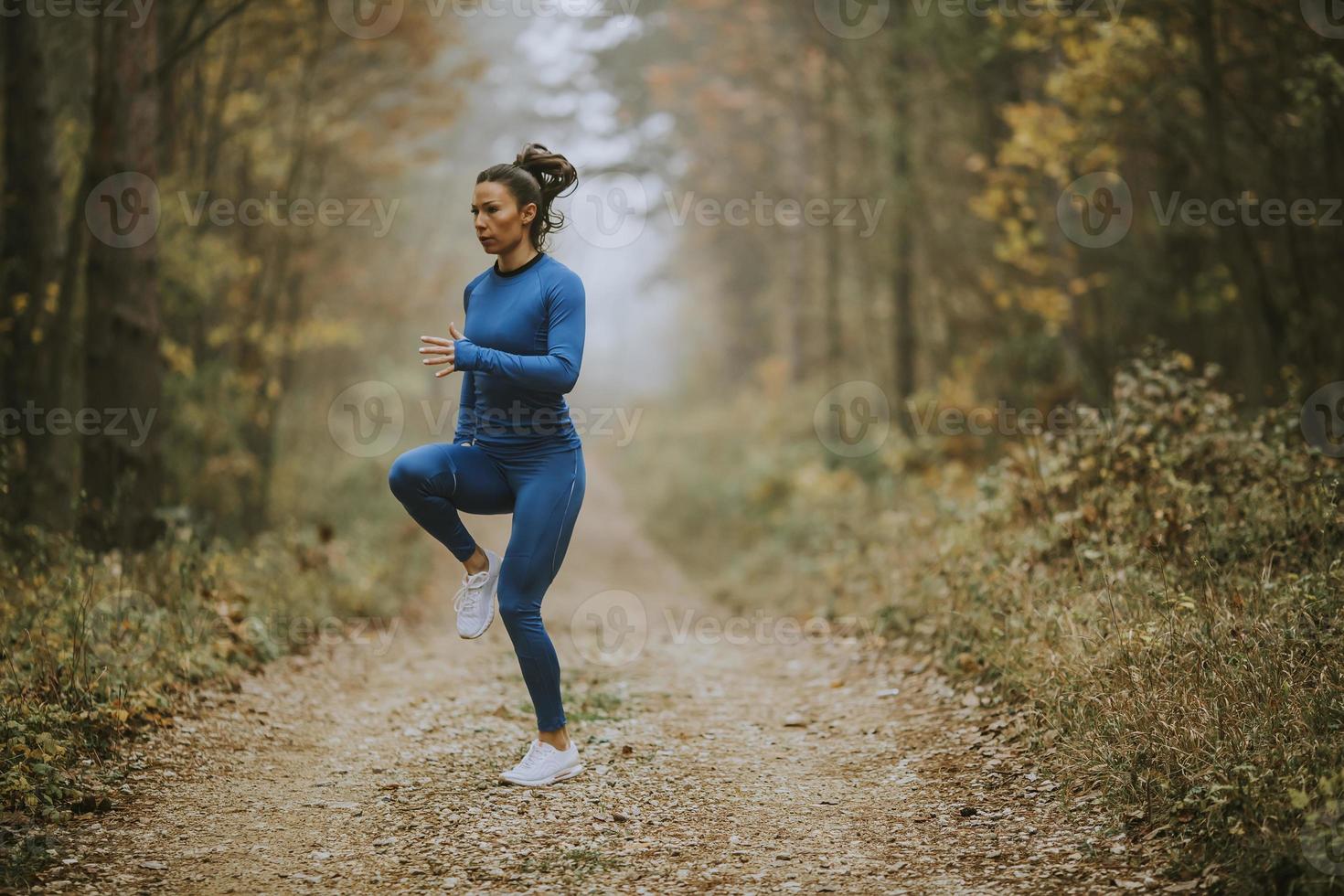 jovem correndo fazendo exercícios na trilha da floresta no outono foto