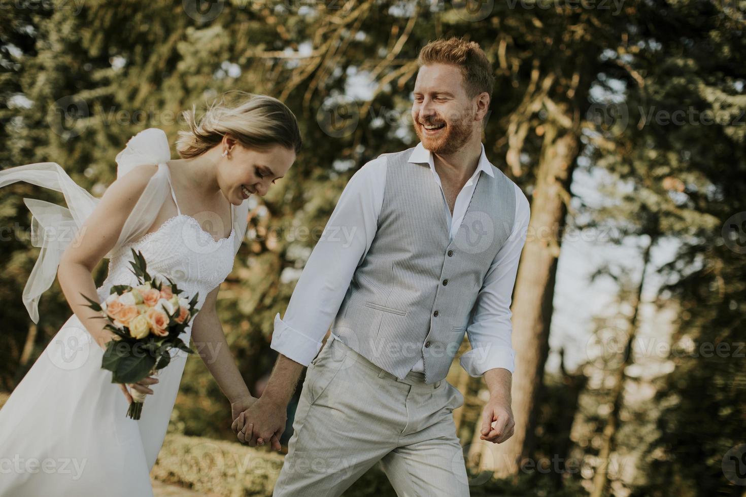 jovem casal recém-casado caminhando no parque foto