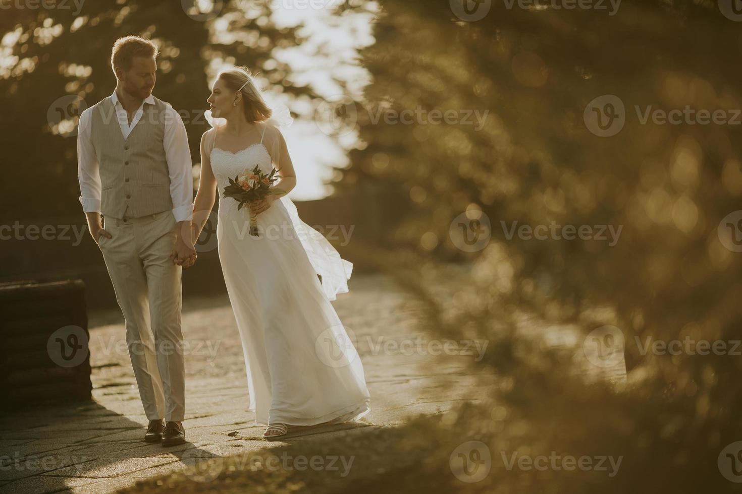 jovem casal recém-casado caminhando no parque foto