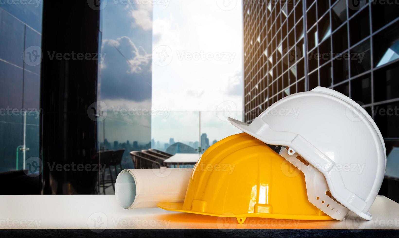 construção de casa e construção. trabalho de reparação. desenhos para construção e capacete na mesa branca. na cidade foto