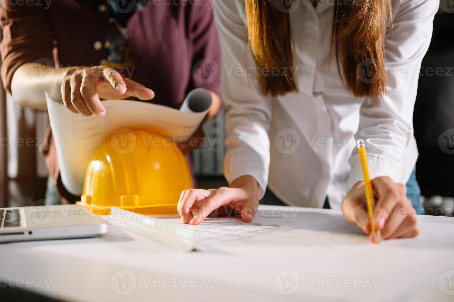 arquiteto criativo projetando grandes desenhos no escritório escuro do loft ou no café à luz da manhã foto