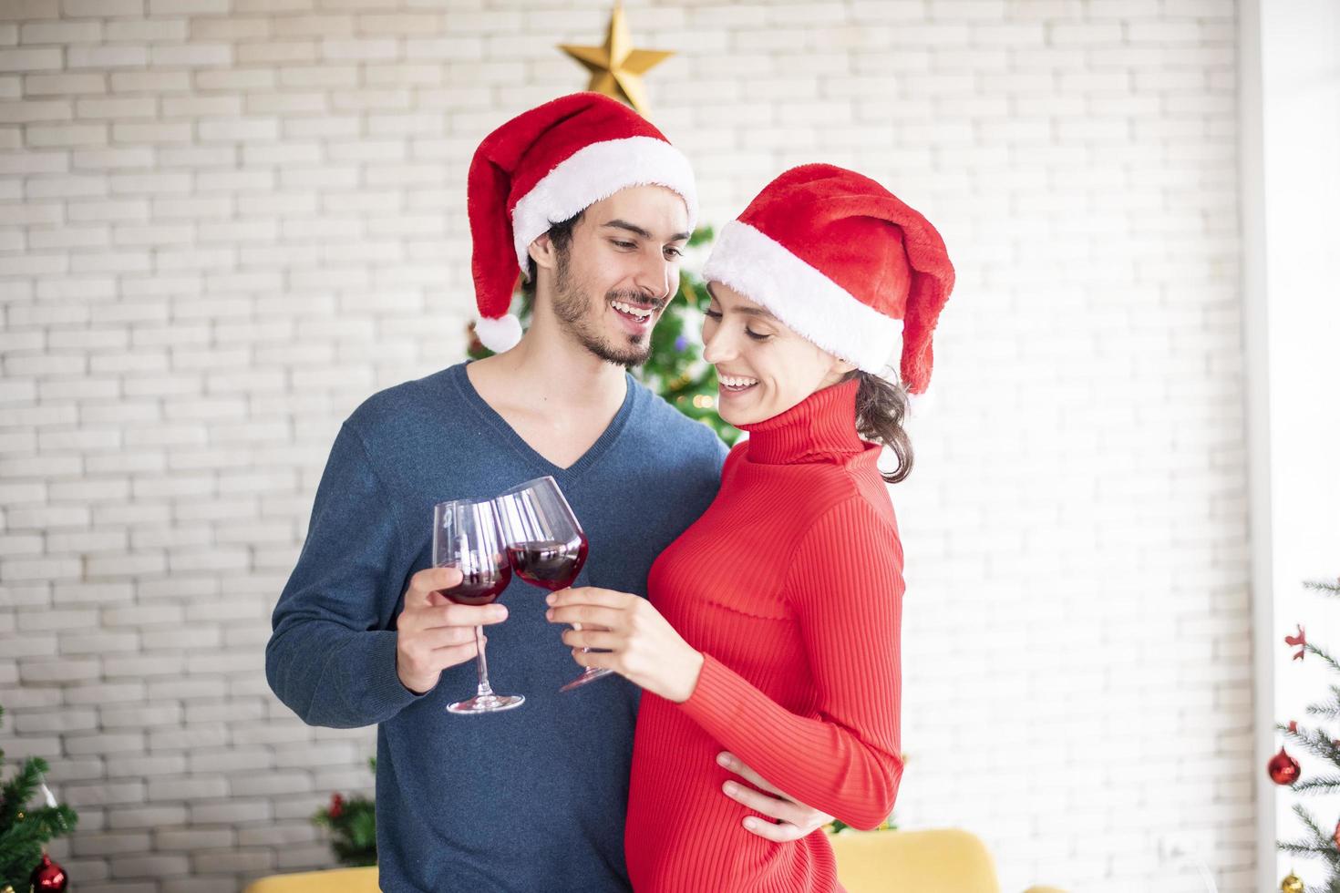 atraente casal caucasiano de amor está comemorando o natal em casa foto