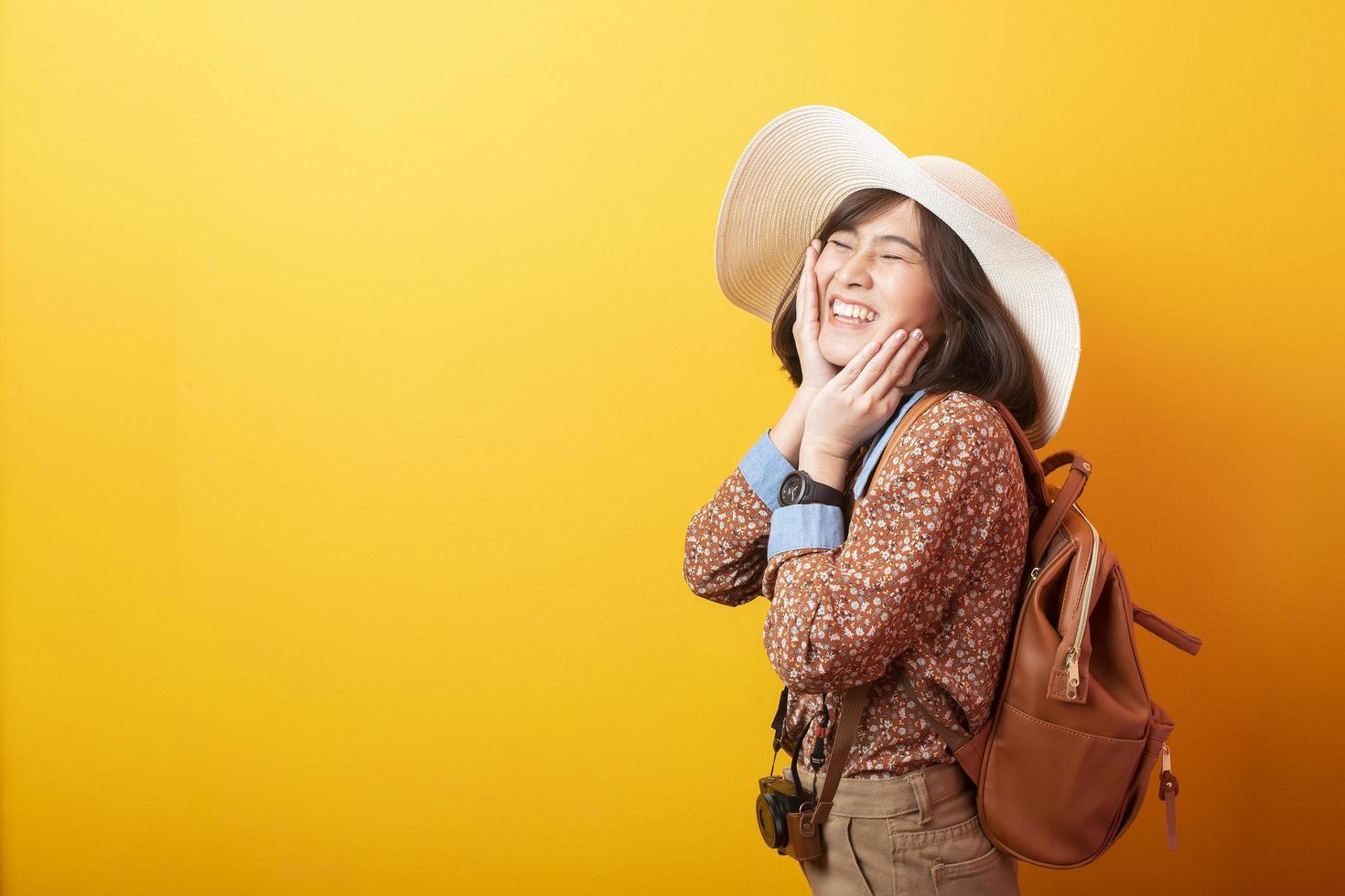 feliz jovem turista asiática em fundo amarelo foto