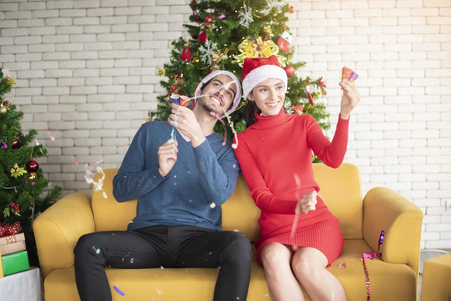 atraente casal caucasiano de amor está comemorando o natal em casa foto