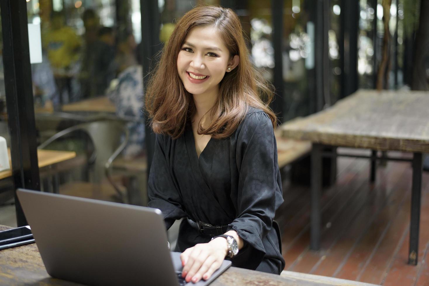 mulher asiática inteligente está trabalhando com computador portátil foto