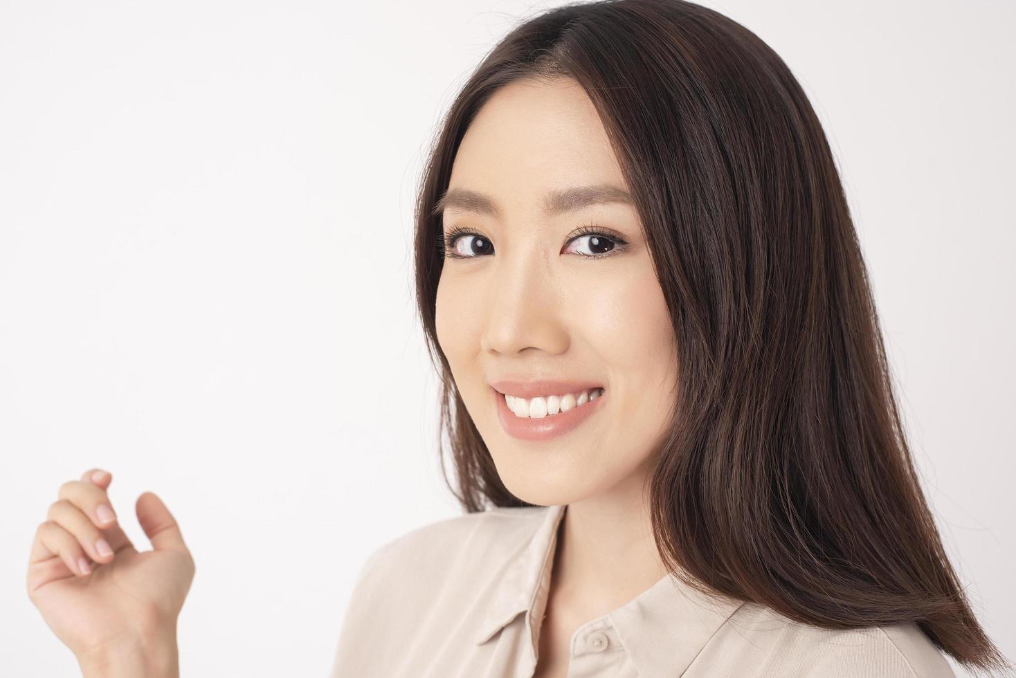 close-up de mulher asiática com belos dentes em fundo branco foto