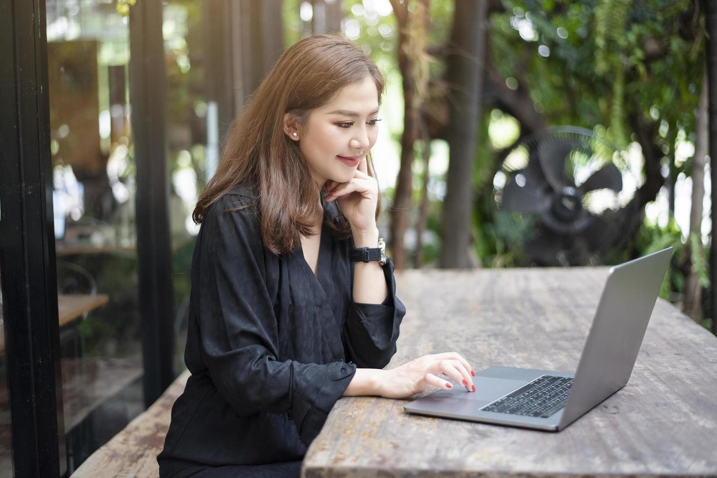 mulher asiática inteligente está trabalhando com computador portátil foto