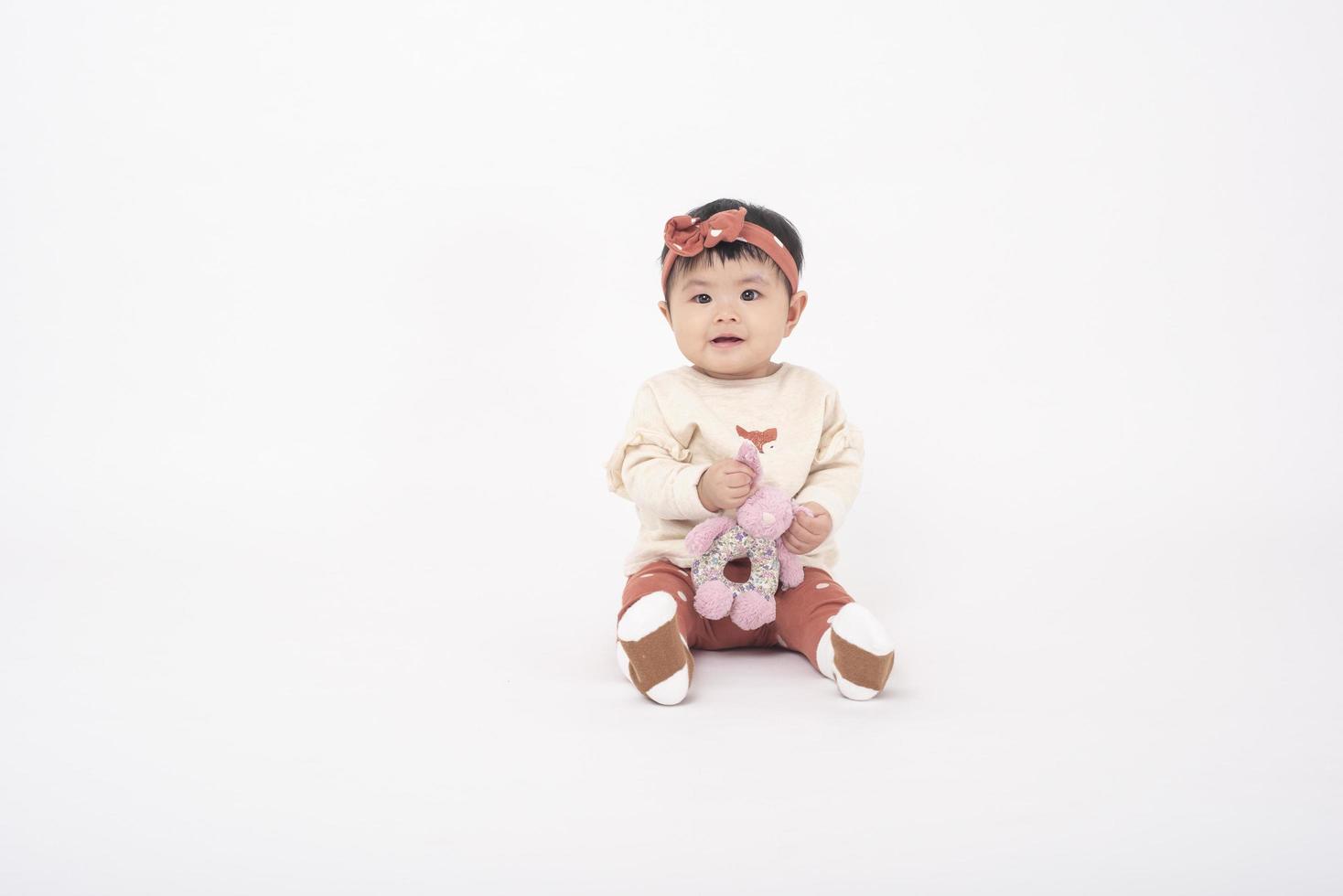 adorável menina asiática é retrato em fundo branco foto