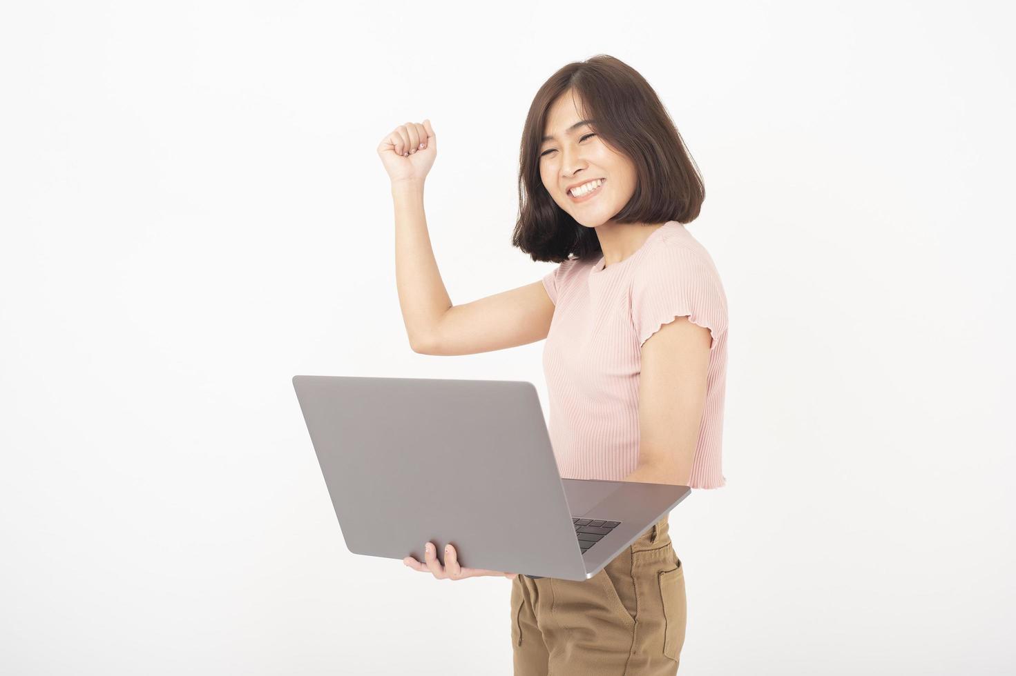 linda mulher adolescente asiática está trabalhando com computador em fundo branco foto