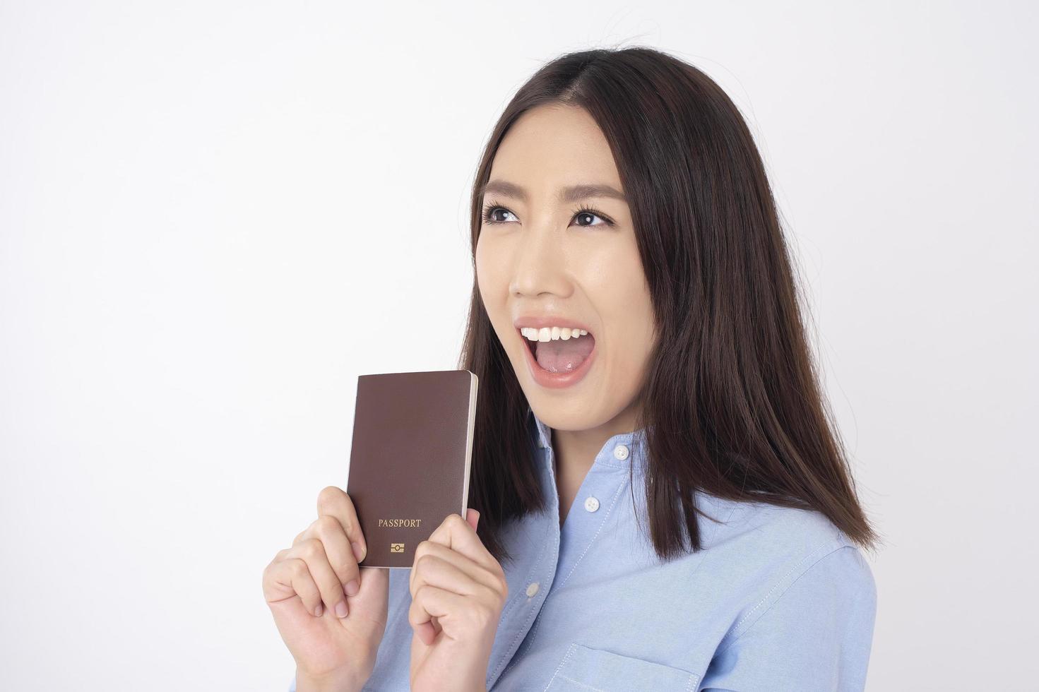 turista linda mulher asiática está segurando passaporte em fundo branco foto