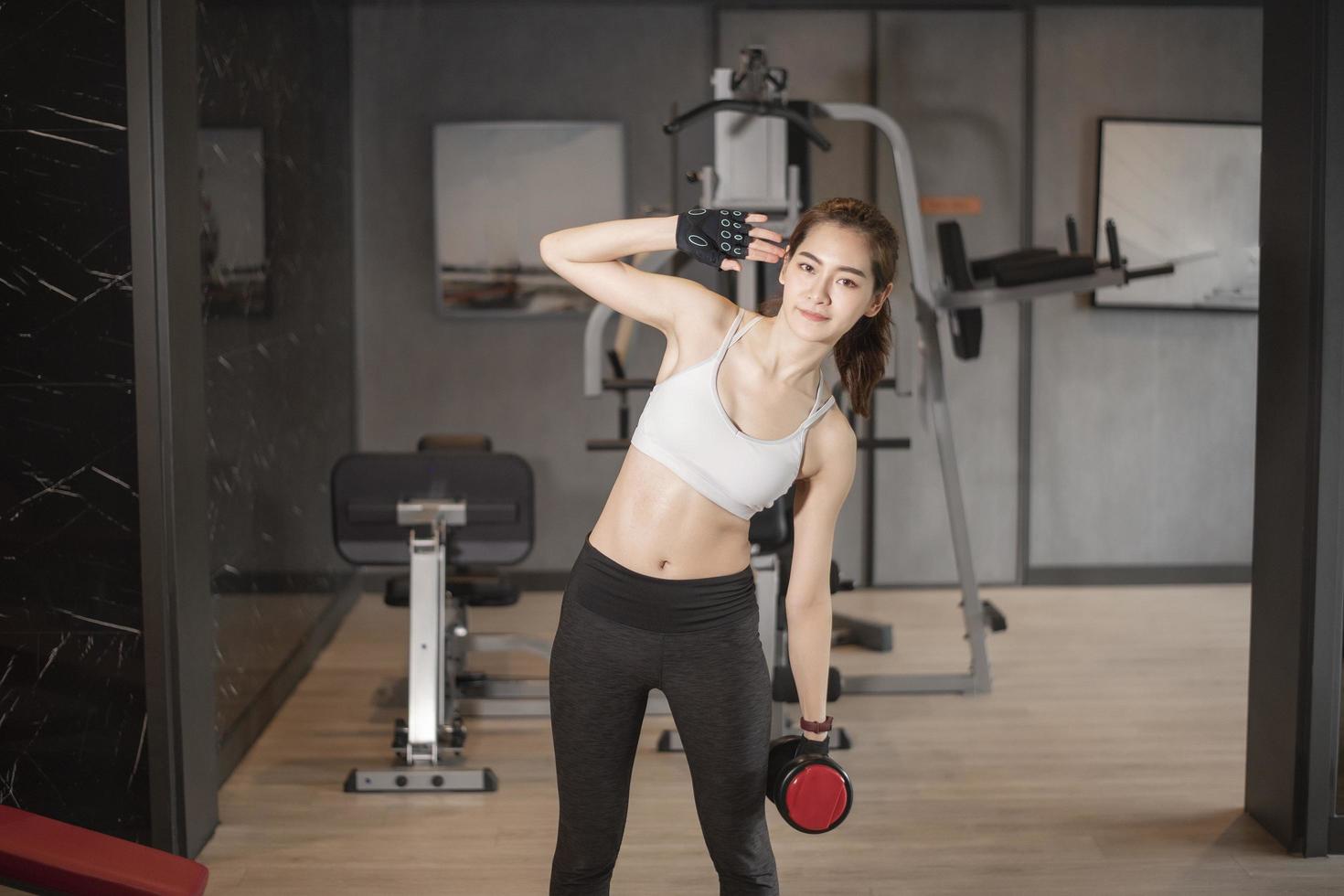 linda mulher asiática está fazendo exercício no ginásio foto