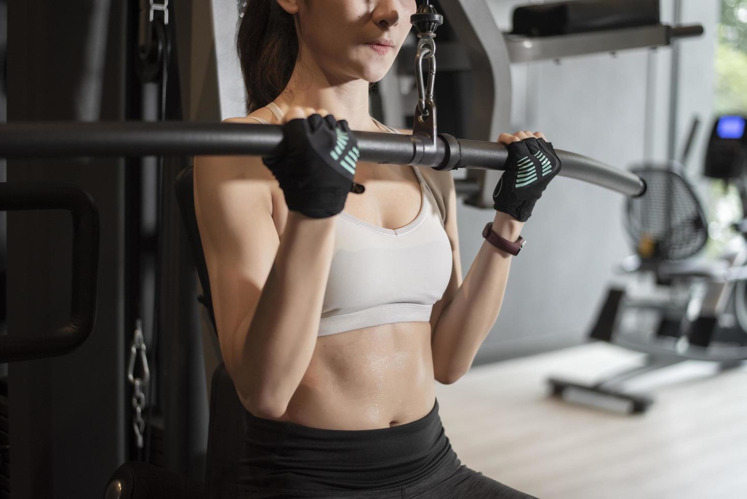 linda mulher asiática está fazendo exercício no ginásio foto