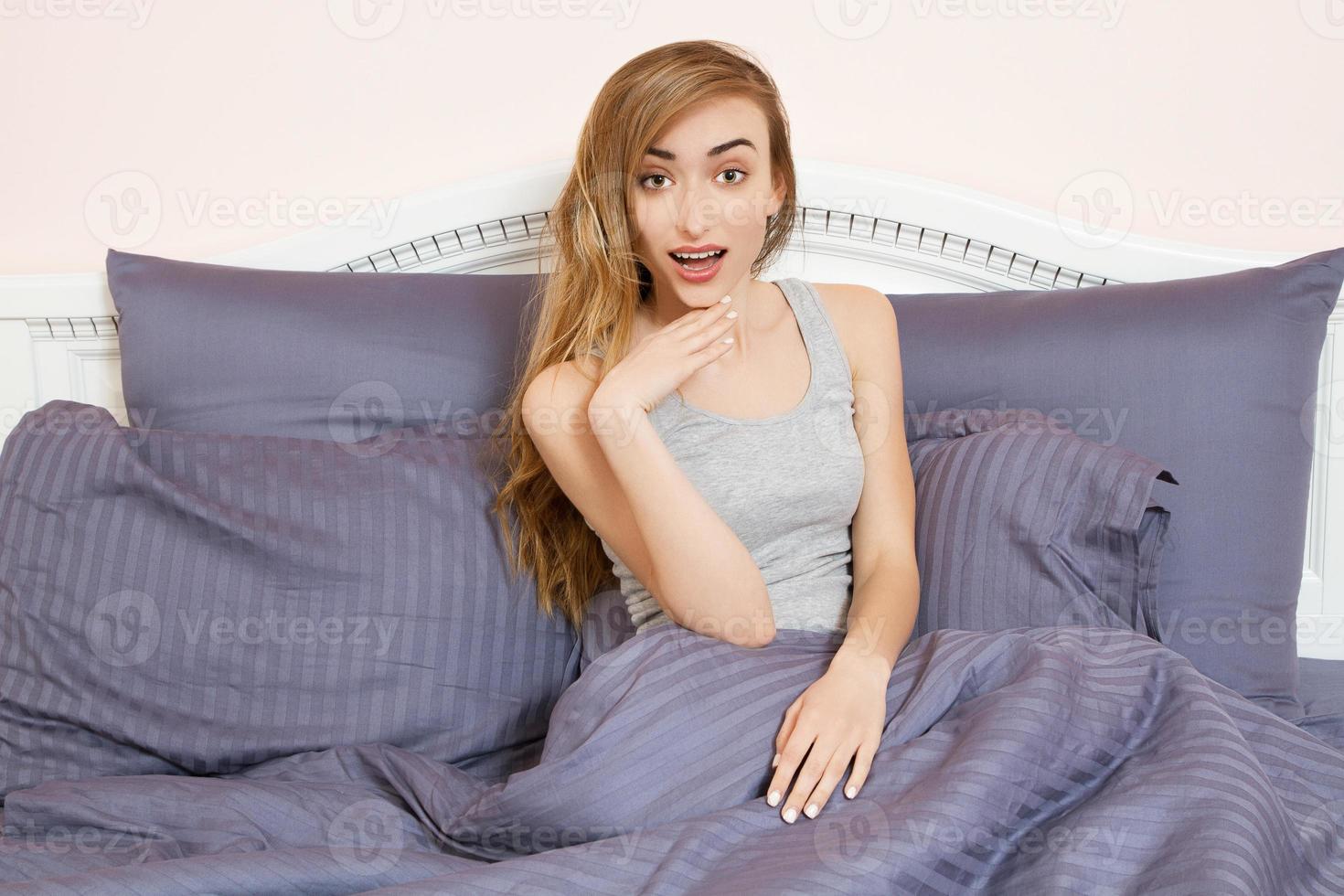 menina emotiomal feliz deitada na cama de manhã, mulher no quarto foto