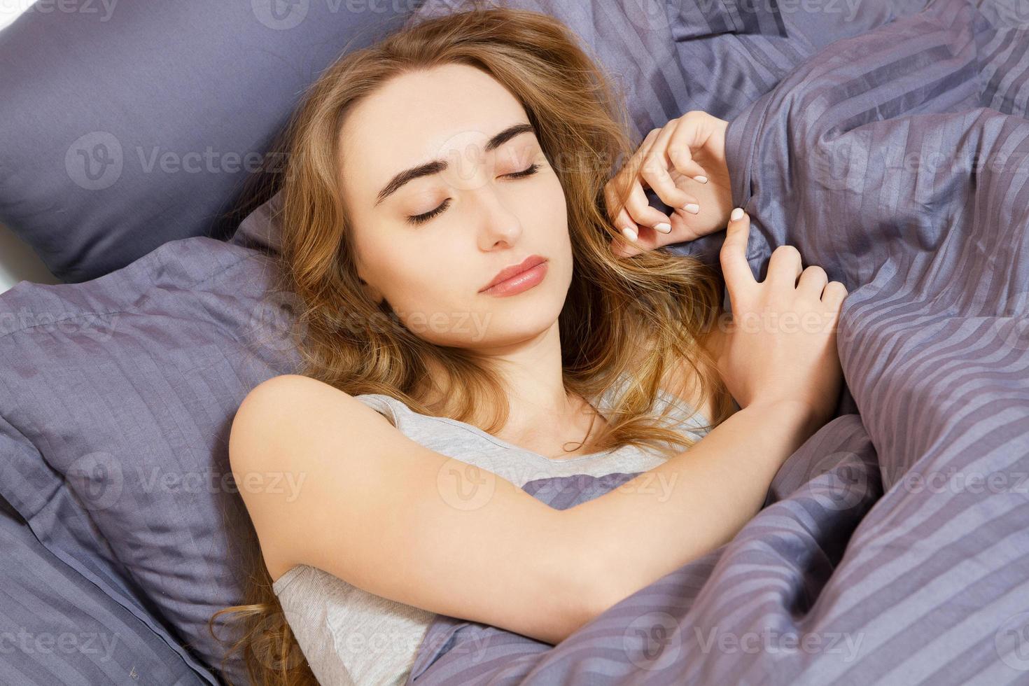 retrato de uma jovem branca dormindo na cama em casa, depois de uma semana difícil foto