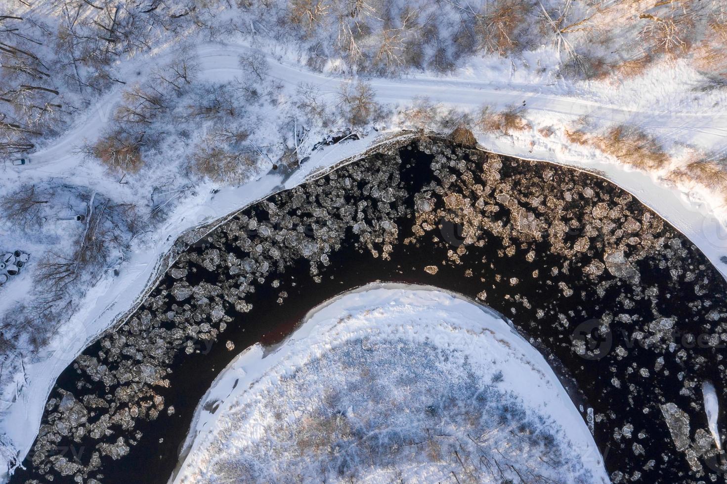 vista aérea de um rio azul e verde com neve e gelo picado durante uma deriva de gelo no inverno foto