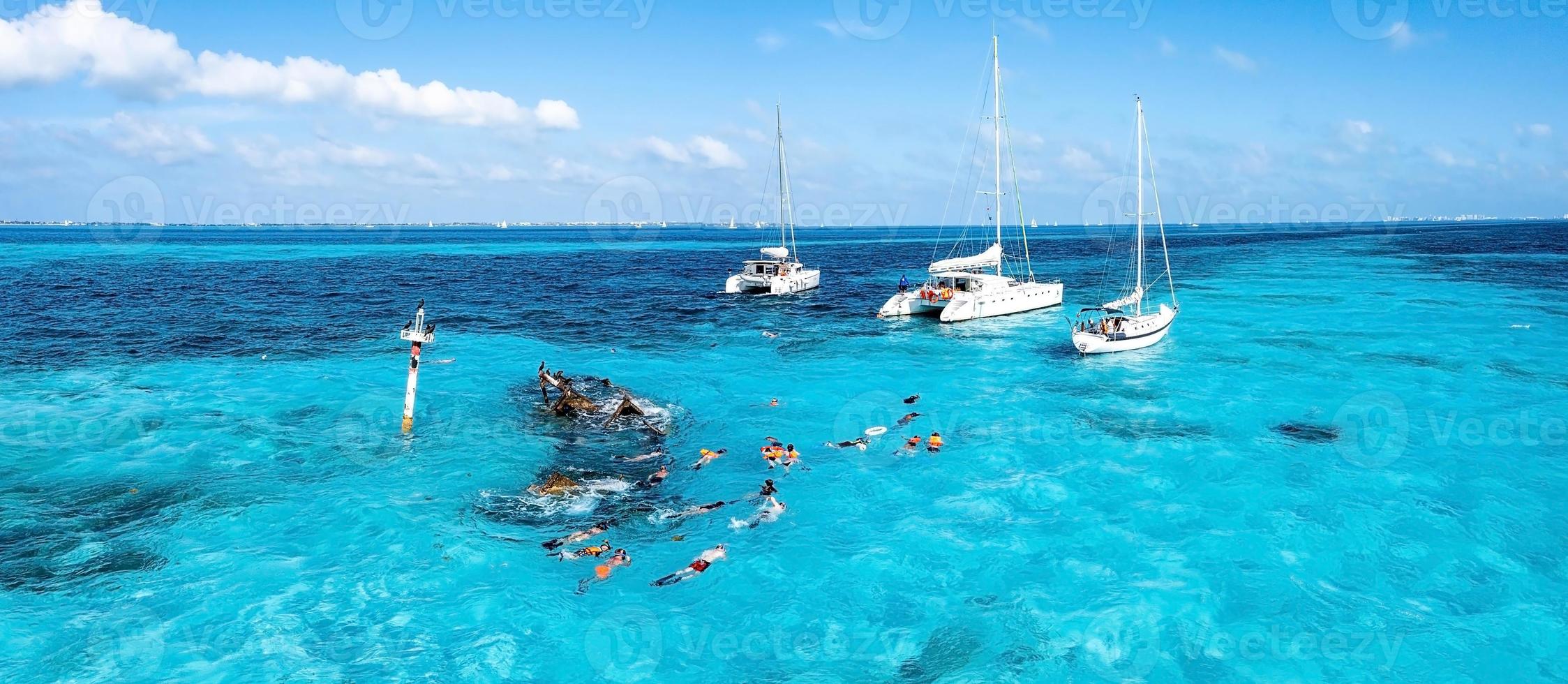 pessoas mergulhando em torno do naufrágio do navio perto das bahamas, no mar do caribe. foto