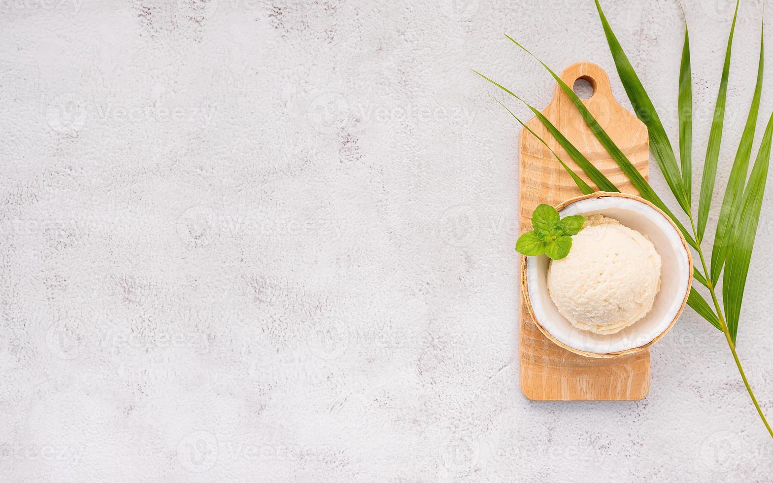 sabores de sorvete de coco na metade da configuração de coco em fundo de pedra branca. verão e conceito de menu doce. foto