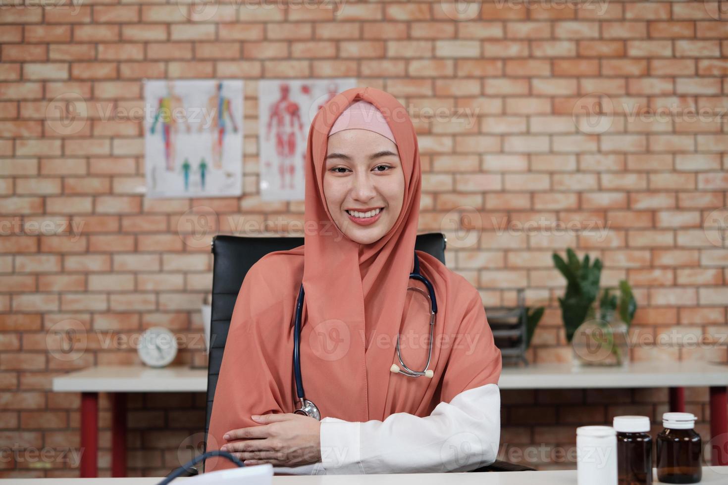 retrato de uma bela médica, bela muçulmana de uniforme com um estetoscópio, sorrindo e olhando para a câmera na clínica do hospital. uma pessoa que tem experiência em tratamento profissional. foto