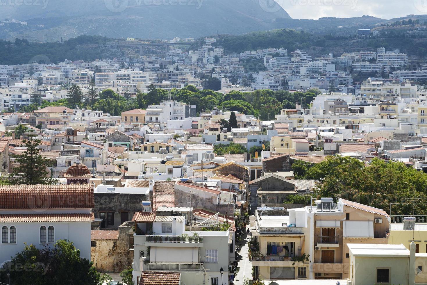 vista do resort arquitetura grega rethymno cidade-porto, construído por venezianos, da altura do castelo fortezza - fortaleza na colina paleokastro. telhados vermelhos e montanhas ao fundo. Creta. foto