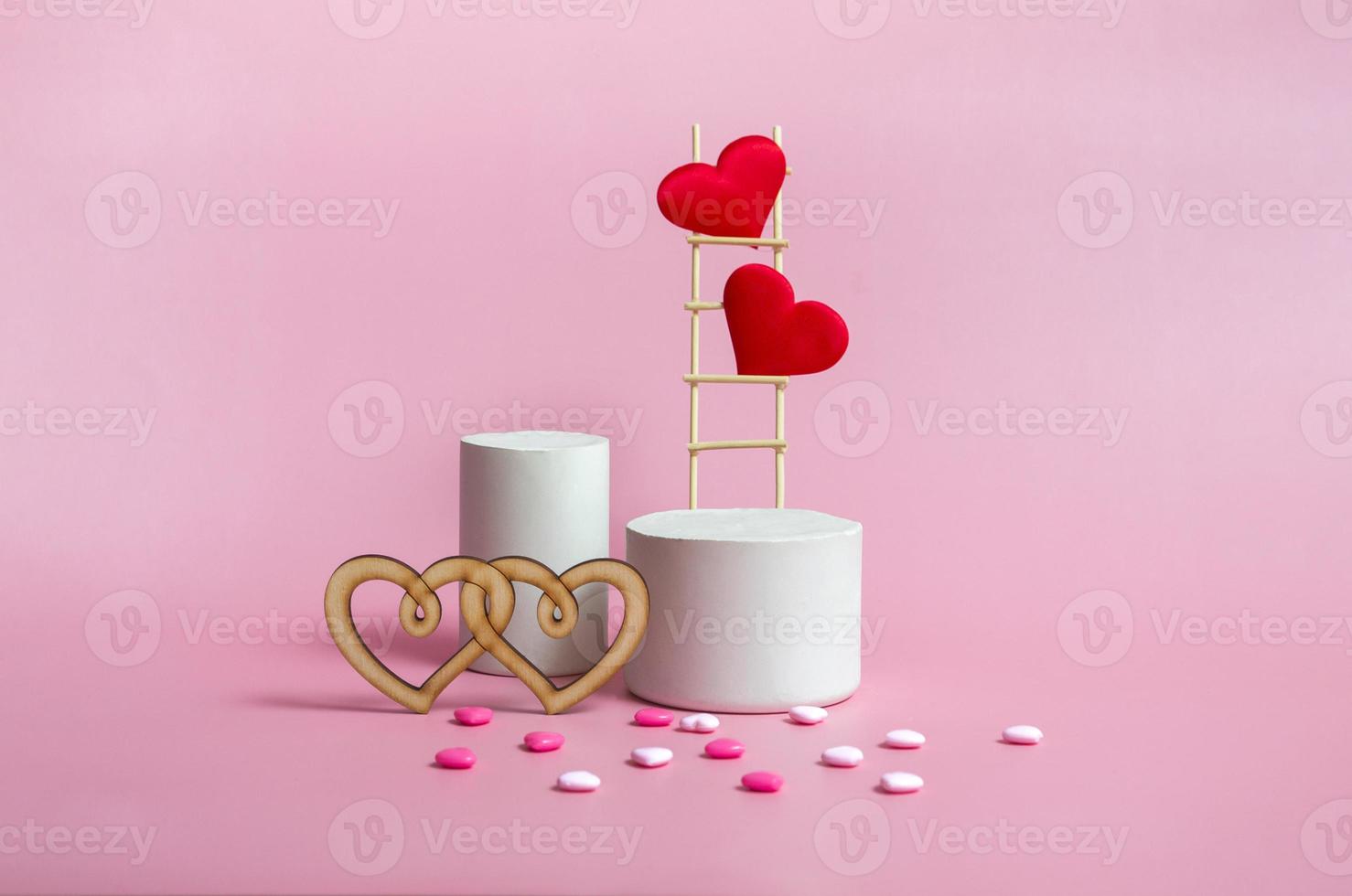 pódio com escadas de madeira e corações em um fundo rosa, monocromático. celebrando o espaço da cópia do dia dos namorados. foto